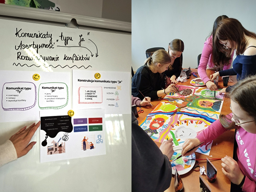 Na lewej części zdjęcia widać białą tablicę z przypiętymi kartkami, na których znajdują się krótkie opisy różnic między komunikatem typu „Ty” i „Ja” oraz zasady budowania komunikatu „Ja”. Na jednej z kartek widoczna jest grafika z osobami rozmawiającymi oraz symbolami emocji. Nad kartkami napisano ręcznie markerem: „Komunikaty typu JA, Asertywność, Rozwiązywanie konfliktów”, od których biegną strzałki skierowane do dołu. Napisy od obrazków oddziela falowana linia. Na tle tablicy widać rękę w jasnym swetrze, która  wskazuje na materiały. Na prawej części zdjęcia widać grupę uczennic siedzących i stojących przy stole. Uczennice  trzymają pędzle w dłoniach i wspólnie malują dużą kolorową pracę plastyczną. Na pracy widać twarze osób, linie, wzory i plamy w żywych kolorach na przykład różowym, zielonym, niebieskim, żółtym i pomarańczowym.  Na stole obok pracy leżą talerzyki, na których znajdują się pędzle i  wymieszane farby oraz tubki z farbami akrylowymi. Widać skupienie i współpracę przy pracy plastycznej.