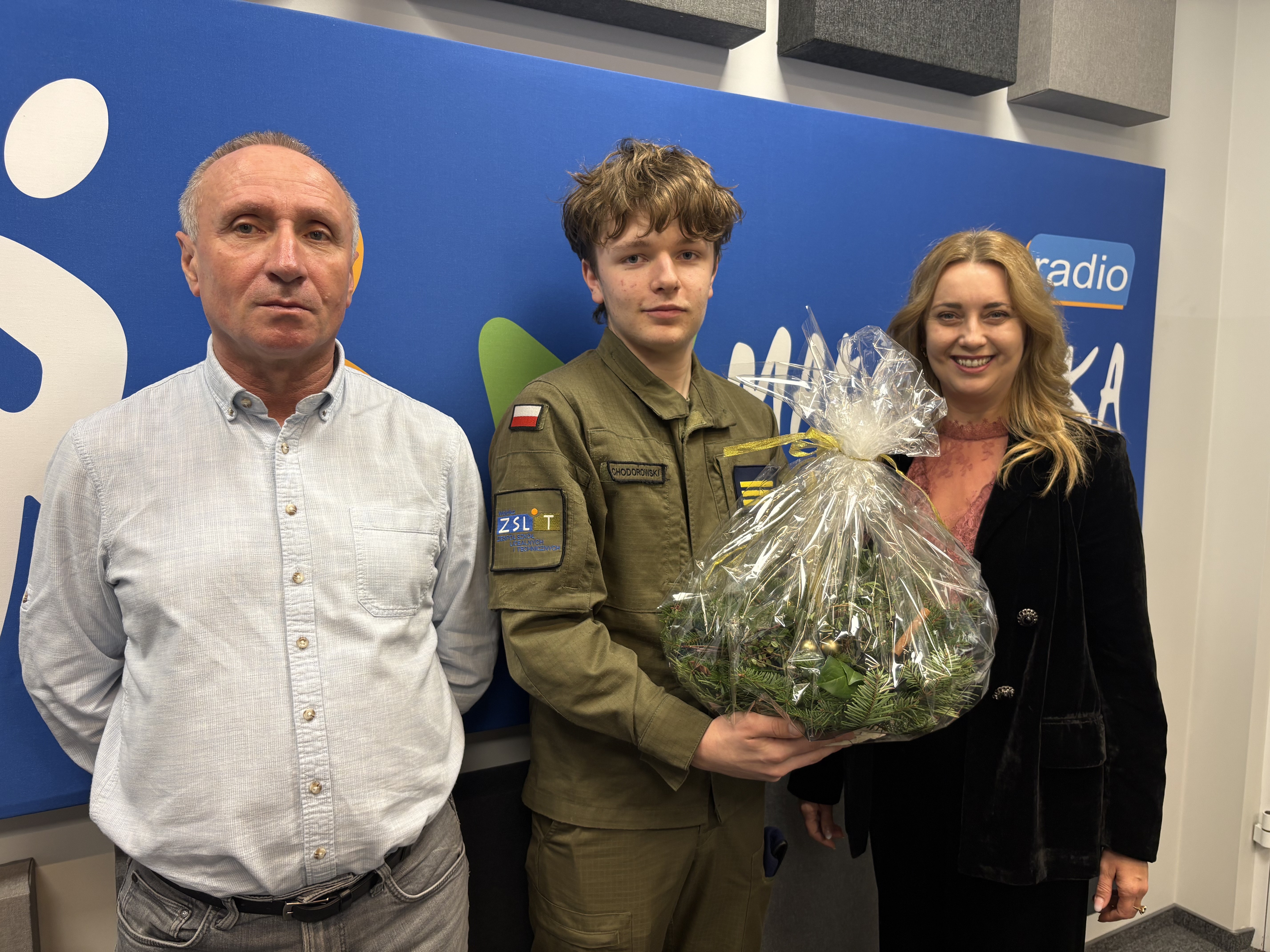 Zdjecie grupowe -uczen z koszem kwiatów wśród nauczycieli