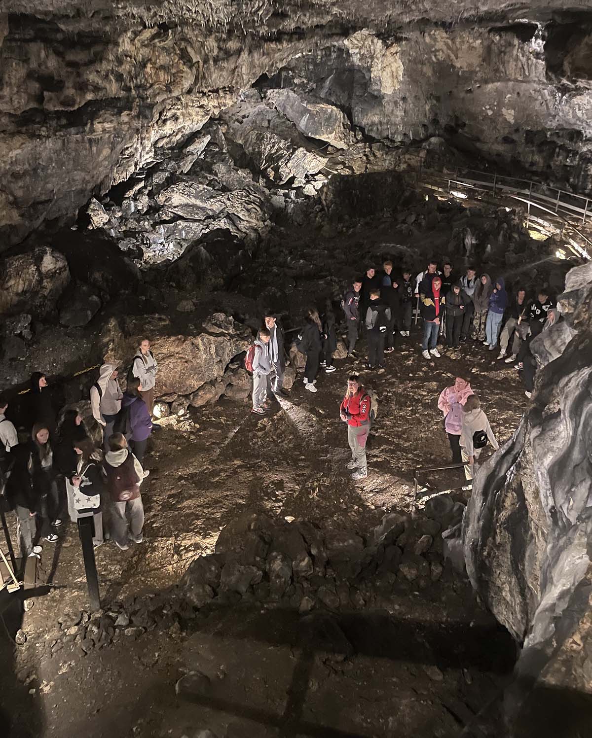 Grupa młodzieży zwiedzająca jaskinię